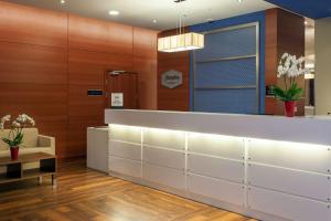 a lobby with a waiting room with white cabinets at Hampton by Hilton Warsaw Airport in Warsaw