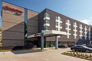 a hotel with a parking lot in front of it at Hampton by Hilton Warsaw Airport in Warsaw