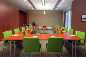 a conference room with long tables and green chairs at Hampton by Hilton Warsaw Airport in Warsaw
