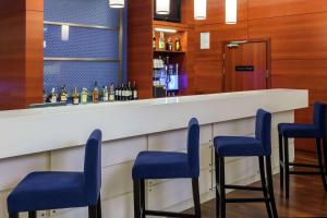 a bar with blue stools in a hotel room at Hampton by Hilton Warsaw Airport in Warsaw