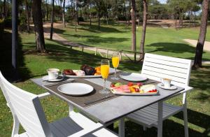 a table with plates of food and glasses of orange juice at DoubleTree by Hilton Islantilla Beach Golf Resort in Islantilla