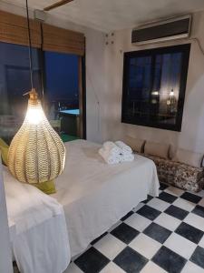 um quarto com uma cama com um candeeiro e um piso em xadrez em Las mil y una noches em Bédar