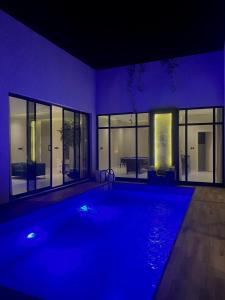 a large swimming pool in a house at night at STAY Villa in Riyadh