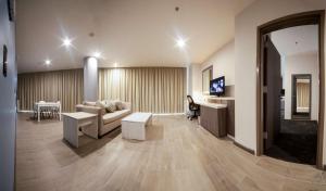 sala de estar con sofá, mesa y TV en Hampton Inn & Suites by Hilton Aguascalientes Aeropuerto, en Aguascalientes