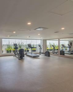 - une salle de sport avec tapis de course et vélos elliptiques dans un bâtiment dans l'établissement Hampton by Hilton Aguascalientes Downtown, à Aguascalientes