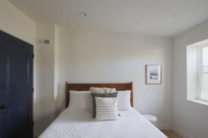 a bedroom with a white bed with pillows and a window at Large 2 BDR With Deck Hosted By StayRafa in Philadelphia
