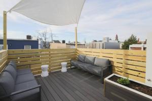 a patio with two couches and an umbrella on a roof at Large 2 BDR With Deck Hosted By StayRafa in Philadelphia