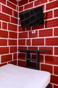 a room with a brick wall with a tv on it at Hostal La Guaca in Cartagena de Indias