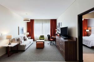 une chambre d'hôtel avec un lit et un salon dans l'établissement Homewood Suites By Hilton Silao Airport, à Silao