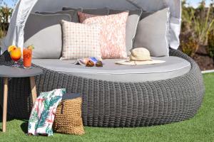 a wicker rattan wicker chair sitting on the grass at Embassy Suites by Hilton Myrtle Beach Oceanfront Resort in Myrtle Beach