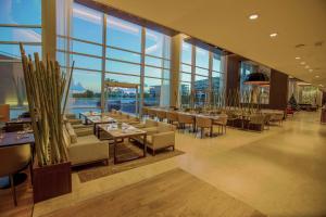 a restaurant with tables and chairs and large windows at Hilton Pilar in Pilar