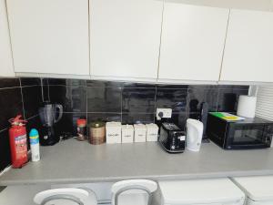 um balcão de cozinha com comodidades para preparar café e um micro-ondas em EXCELLENT DOUBLE ROOMS IN CHEAP RATE AROUND CENTRAL LONDON em Londres
