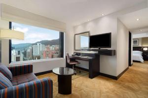 a hotel room with a desk and a large window at Hilton Bogotá in Bogotá
