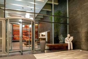 a lobby with a statue of a woman sitting on a bench at Hilton Garden Inn Chihuahua in Chihuahua