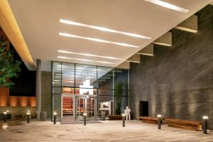 eine Lobby eines Gebäudes mit Bänken und Fenstern in der Unterkunft Hilton Garden Inn Chihuahua in Chihuahua