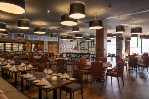 un ristorante con tavoli e sedie e un bar di Doubletree By Hilton Celaya a Celaya