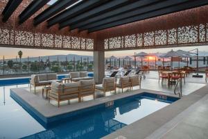 un complexe avec une piscine, des chaises et des tables dans l'établissement Doubletree By Hilton Celaya, à Celaya