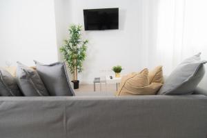 een bank met kussens en een televisie in de woonkamer bij Alojamiento Guayarmina in La Restinga