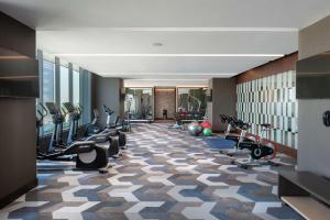 einen Fitnessraum mit Laufbändern und Trainingsgeräten in einem Gebäude in der Unterkunft Hilton Guadalajara Midtown in Guadalajara