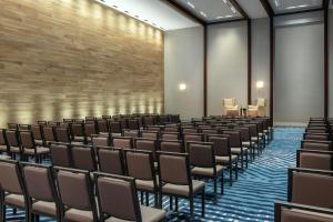 an empty room with chairs and a wall at Hilton Guadalajara Midtown in Guadalajara