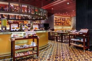 a restaurant with a counter and tables with food at Hilton Lima Miraflores in Lima