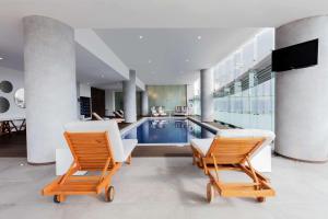 uma casa com piscina e duas cadeiras em Doubletree By Hilton Mexico City Santa Fe em Cidade do México