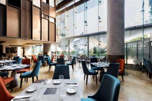 un restaurante con mesas, sillas y ventanas en Doubletree By Hilton Mexico City Santa Fe, en Ciudad de México