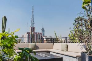 a couch on a rooftop with a view of the city at Umbral, Curio Collection By Hilton in Mexico City