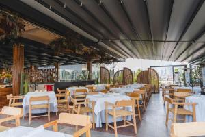 un restaurante con mesas blancas y sillas de madera en Umbral, Curio Collection By Hilton, en Ciudad de México