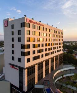 a building with a sign on the top of it at Hilton Garden Inn Merida in Mérida