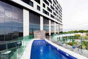 a view of a building with a swimming pool at Hilton Garden Inn Merida in Mérida