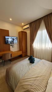 a hotel room with a bed and a desk and a window at KBK Lodge in Abaga