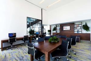 Hilton Garden Inn Merida في ميريدا: مكتب به طاولة وكراسي خشبية كبيرة