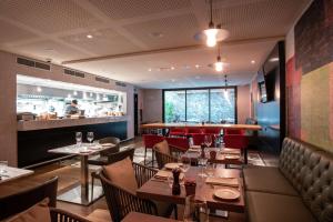 a restaurant with tables and chairs and a bar at Soro Montevideo, Curio Collection By Hilton in Montevideo