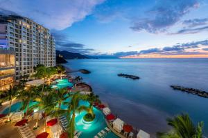 Hilton Vallarta Riviera All-Inclusive Resort,Puerto Vallarta في بويرتو فايارتا: اطلالة جوية للفندق والمحيط وقت الغروب