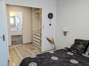 een slaapkamer met een bed, een spiegel en een wastafel bij La Villa Blanca Montpellier Piscine & proximité Mer in Saint-Jean-de-Védas
