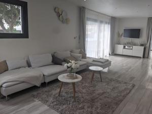 een woonkamer met een bank en een tafel bij La Villa Blanca Montpellier Piscine & proximité Mer in Saint-Jean-de-Védas