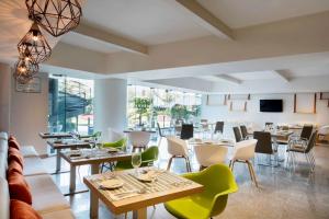 a restaurant with tables and chairs in a room at Hilton Garden Inn Mexico City Santa Fe in Mexico City