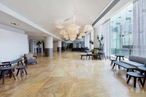 a large lobby with tables and chairs in a building at Hilton Garden Inn Mexico City Santa Fe in Mexico City