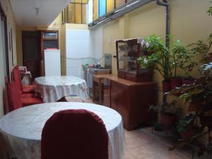 una habitación con 2 mesas y una cocina con plantas en Naty's Guest House, en Cusco