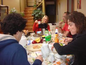a group of people sitting around a table eating food at Naty's Guest House in Cusco +40 photos