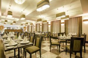 une salle à manger avec des tables, des chaises et des lustres dans l'établissement Hilton Garden Inn Tuxtla Gutierrez, à Tuxtla Gutiérrez