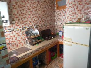 a kitchen with a sink and a white refrigerator at Dar Si Tawfik for Couples and Famillies in Chefchaouene