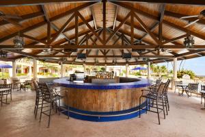 un bar en un complejo con sillas y mesas en Embassy Suites by Hilton Dorado del Mar Beach Resort en Dorado