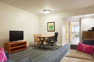 een woonkamer met een tafel en een televisie bij Embassy Suites by Hilton Dorado del Mar Beach Resort in Dorado