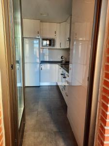 a kitchen with white appliances and a tile floor at Apartamento Bulevar in Burgos +3 photos