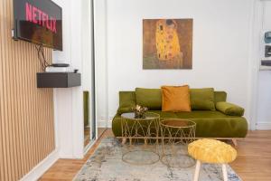 uma sala de estar com um sofá verde e uma televisão em Parisian & Chic Appartement -15 min from Paris Center em Ivry-sur-Seine