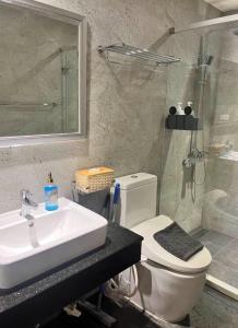 a bathroom with a sink and a toilet and a shower at Toucheng Coolbreeze Holmestay in Toucheng