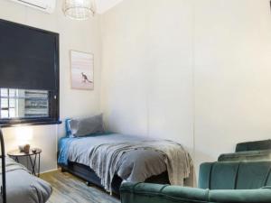 een slaapkamer met een bed, een bank en een stoel bij Royal hotel tambar springs 