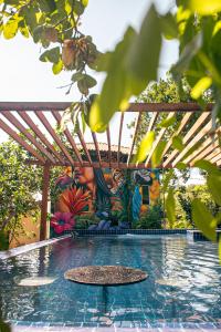 a swimming pool with a wooden pergola with a painting at Pousada e Restaurante Amazonia in Alter do Chao